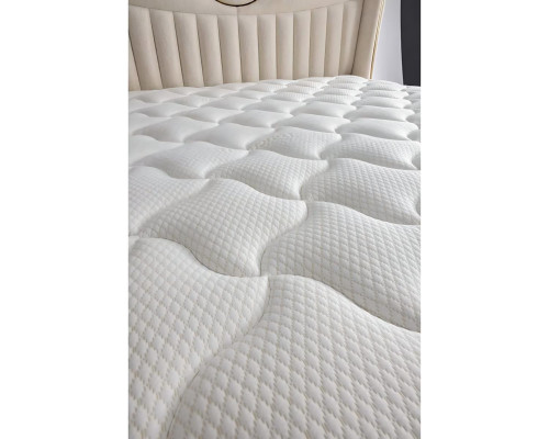 Elegantná posteľ s vankúšmi z svetlo sivej tkaniny a dreva