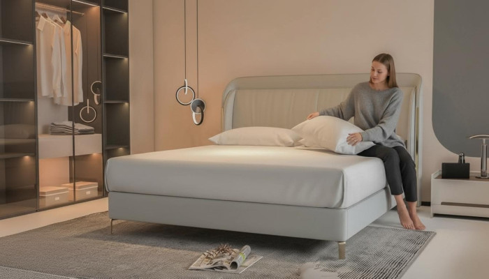 Moderná luxusná posteľ s elegantným zlatým čelom v sivej farbe